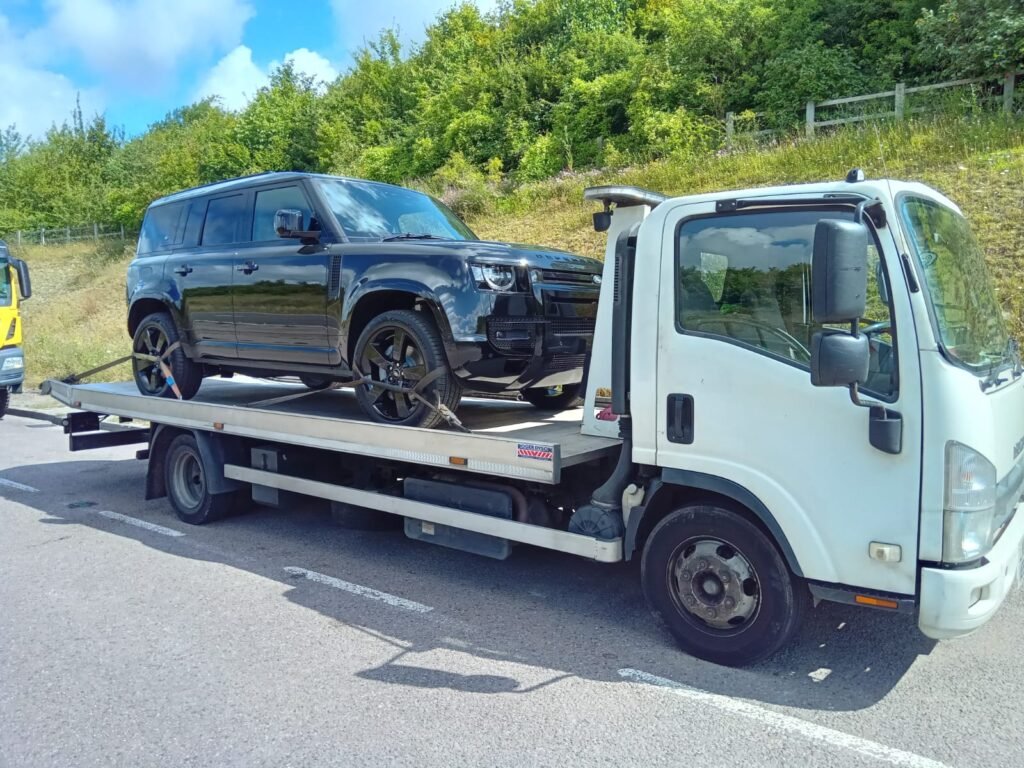 Black 4x4 secured on recovery truck